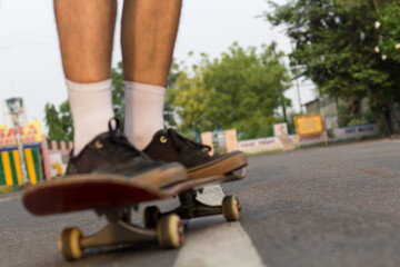 Blurred closeup shot of someone's feet who is cruising on a skateboard on an empty road. 