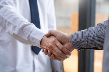 Fototapeta premium Two confident business man shaking hands during a meeting in the office, success, dealing, greeting and partner concept