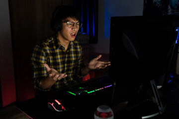 Asian man cyber sport gamer concentrated playing video games on computer eSport concept © snowing12