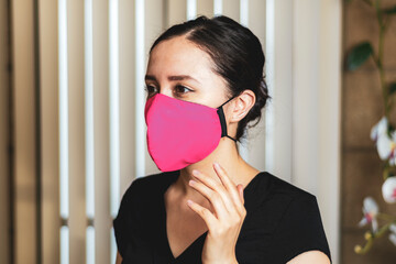 Woman wearing a pink facemask, indoors