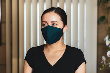 Woman wearing a blue facemask, indoors 
