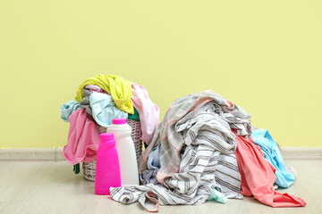 Baskets with dirty clothes near color wall