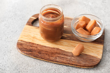 Jar and bowl with caramel on table