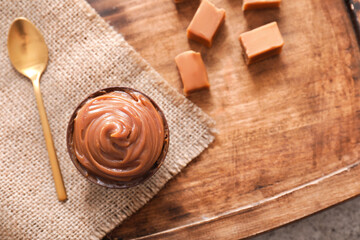 Bowl with liquid caramel on table