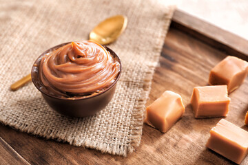 Bowl with liquid caramel on table