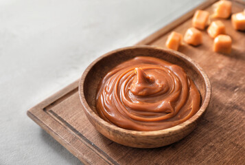 Bowl with liquid caramel on table