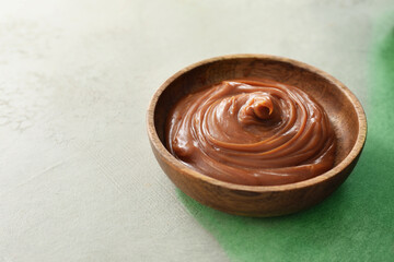 Bowl with liquid caramel on table