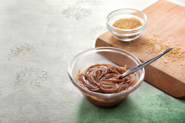 Bowl with liquid caramel on table