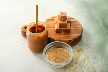 Composition with sweet caramel and sugar on table