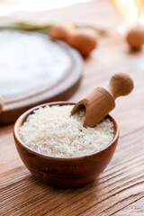 Bowl with rice and scoop on table