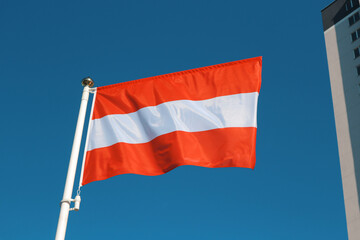 Flag of Austria against the blue sky.