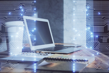 Computer on desktop in office with technology theme hologram. Double exposure. Tech concept.