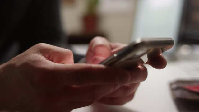 Close up of thumbs texting on a smartphone with shallow focus
