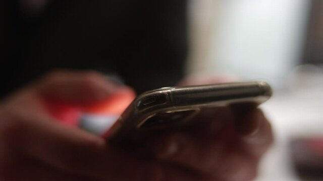 Extreme close up of fingers using a smartphone with shallow focus