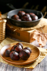 Obraz premium chestnuts in wooden plate