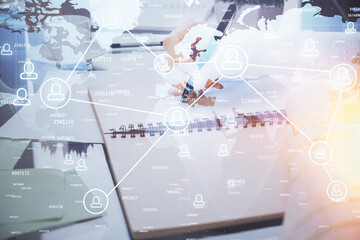 Social network theme hologram over hands taking notes background. Concept of global international people connect. Double exposure