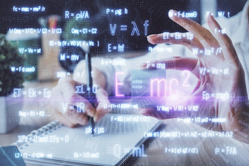 Science formula hologram over woman's hands taking notes background. Concept of study. Double exposure