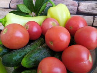 Food still life on the kitchen table pepper tomatoes cucumbers cherry plum garlic dill herbs grape leaves