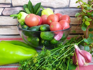 Food still life on the kitchen table pepper tomatoes cucumbers cherry plum garlic dill herbs grape leaves
