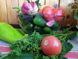 Food still life on the kitchen table pepper tomatoes cucumbers cherry plum garlic dill herbs grape leaves