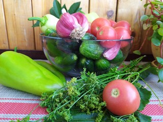 Food still life on the kitchen table pepper tomatoes cucumbers cherry plum garlic dill herbs grape leaves