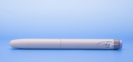 Insulin pen isolated over blue background