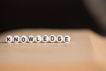 The word knowledge on a book,selective focus,dark background