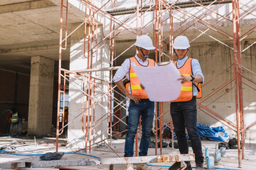 Project engineer, engineer working on blueprint architectural project at construction site