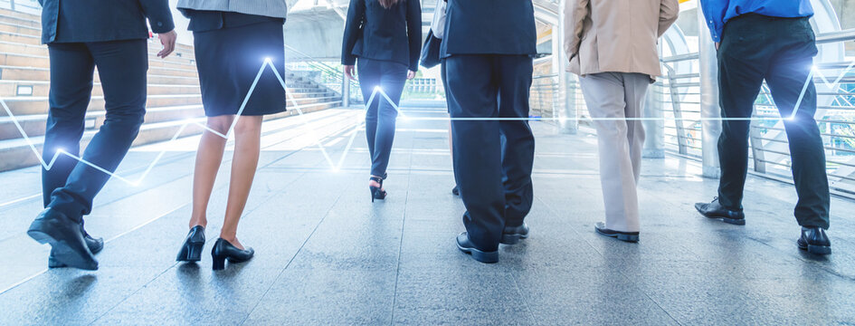 legs of business people walking in the modern city with Stock market or forex trading graph.