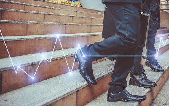defocused or blured Businessman walking the stairs with city background, Businessmen go to success concept with Stock market or forex trading graph.