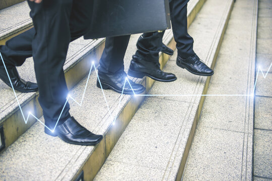 legs of business people walking in the modern city with Stock market or forex trading graph.