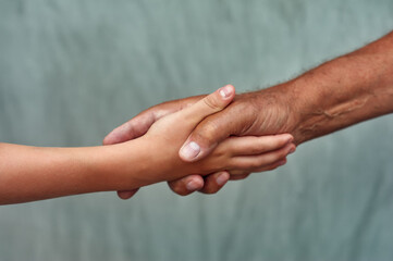 Hands of the son and father close-up . Family concept of care and love