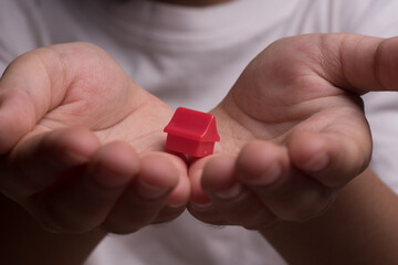 A miniature house on top of a child hand