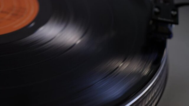 Close up of a vinyl record getting put on a turntable and the needle dropping