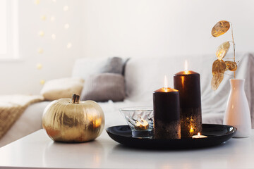 Obraz na płótnie Canvas home decor with golden pumpkin and burning candles