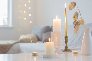 burning candles on table in white interior