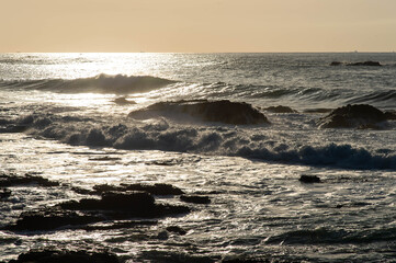 朝日に輝く海と波