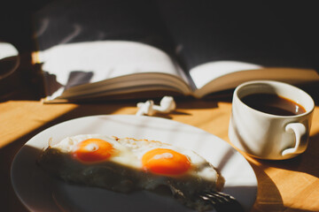 breakfast on the table coffee fried eggs and ripe cherries in the sunlight