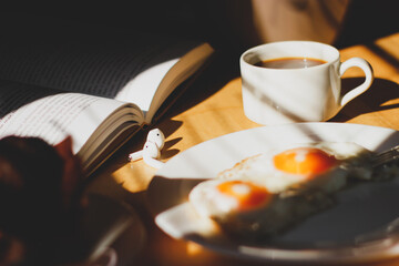 breakfast on the table coffee fried eggs and ripe cherries in the sunlight