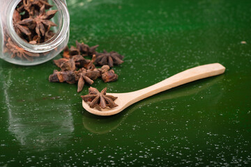 Star anise over green wooden background