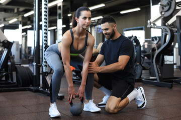 Fototapeta na wymiar Fitness instructor exercising with his client at the gym.