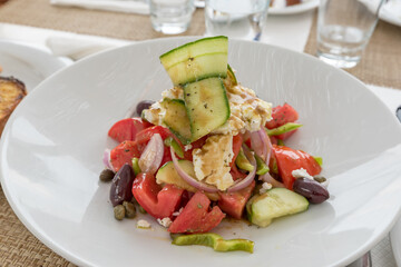 Greek salad with feta tomato onion peppers olives capers and zucchini