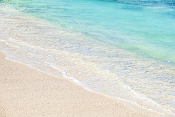 Wave of blue ocean on sandy white beach, texture background.