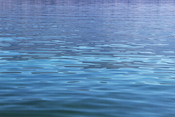 Naklejka premium Light blue wavy calm water surface background