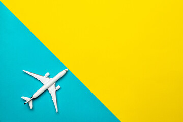 Play airplane white toy in flight travel concept. sky air plane or aircraft on fly yellow and bright blue background.