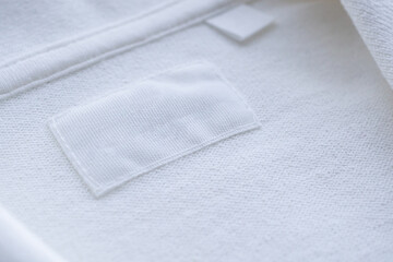 Fototapeta na wymiar Blank white clothes label on new shirt background
