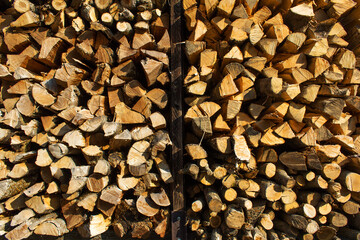 Wooden background of firewood wall near rural house eco alternative heating  energy concept