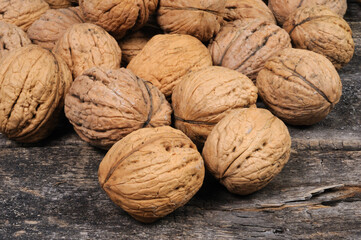 Walnuts are scattered on a wooden surface. Front view.