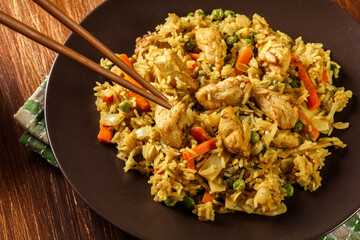 Fried rice nasi goreng with chicken and vegetables on a plate