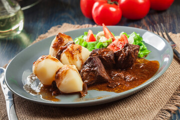 Pork meat stew served with potatoes and vegetable salad